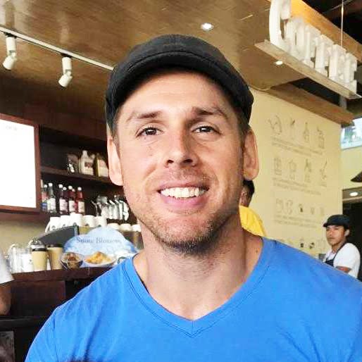 Man wearing a black cap smiling at the camera